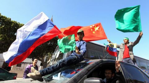 Partidarios de Gadafi ondean la bandera Libia junto a las de China y Rusia