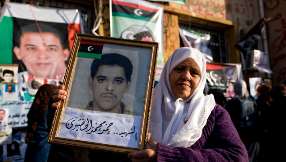 Una mujer muestra el retrato de su hijo desaparecido en Bengasi