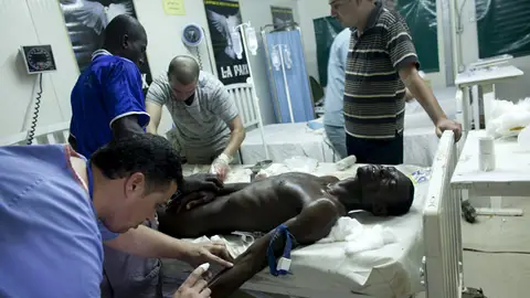 Un médico atiende a un herido en Abiyan Un médico atiende a un herido en Abiyan