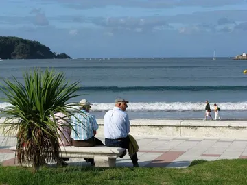 Imagen de archivo: jubilados sentados en un banco frente a la playa Imagen de archivo: jubilados sentados en un banco frente a la playa