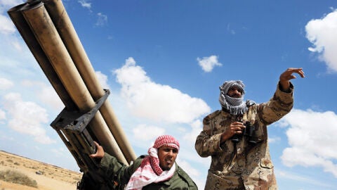 Soldados rebeldes libios conversan detr&aacute;s de un lanzamisiles 