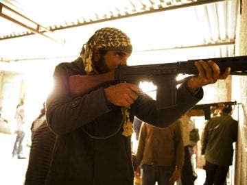 Un grupo de rebeldes opositores a Muamar el Gadafi participan en la toma de una casa