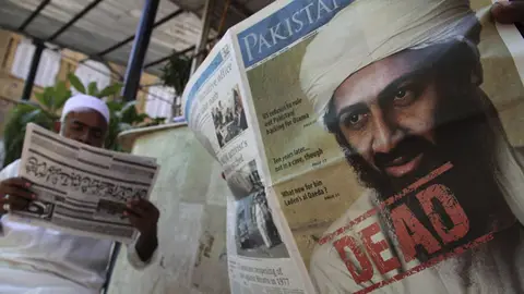 Los paquistanís leen los periódicos del día Los paquistanís leen los periódicos del día