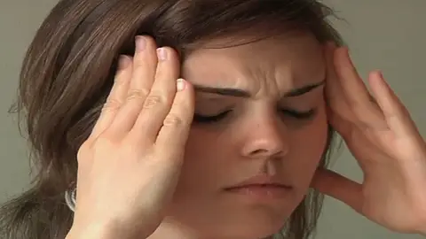 Una mujer sufriendo migrañas Una mujer sufriendo migrañas