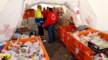 Voluntarios de Cruz Roja preparan el desayuno en una carpa de Lorca