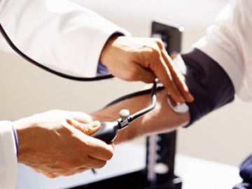 Un médico mide la presión arterial
