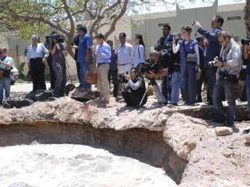 Los reporteros gráficos observan el crater causado por un bombardeo de la OTAN en Bab al-Aziziya. 