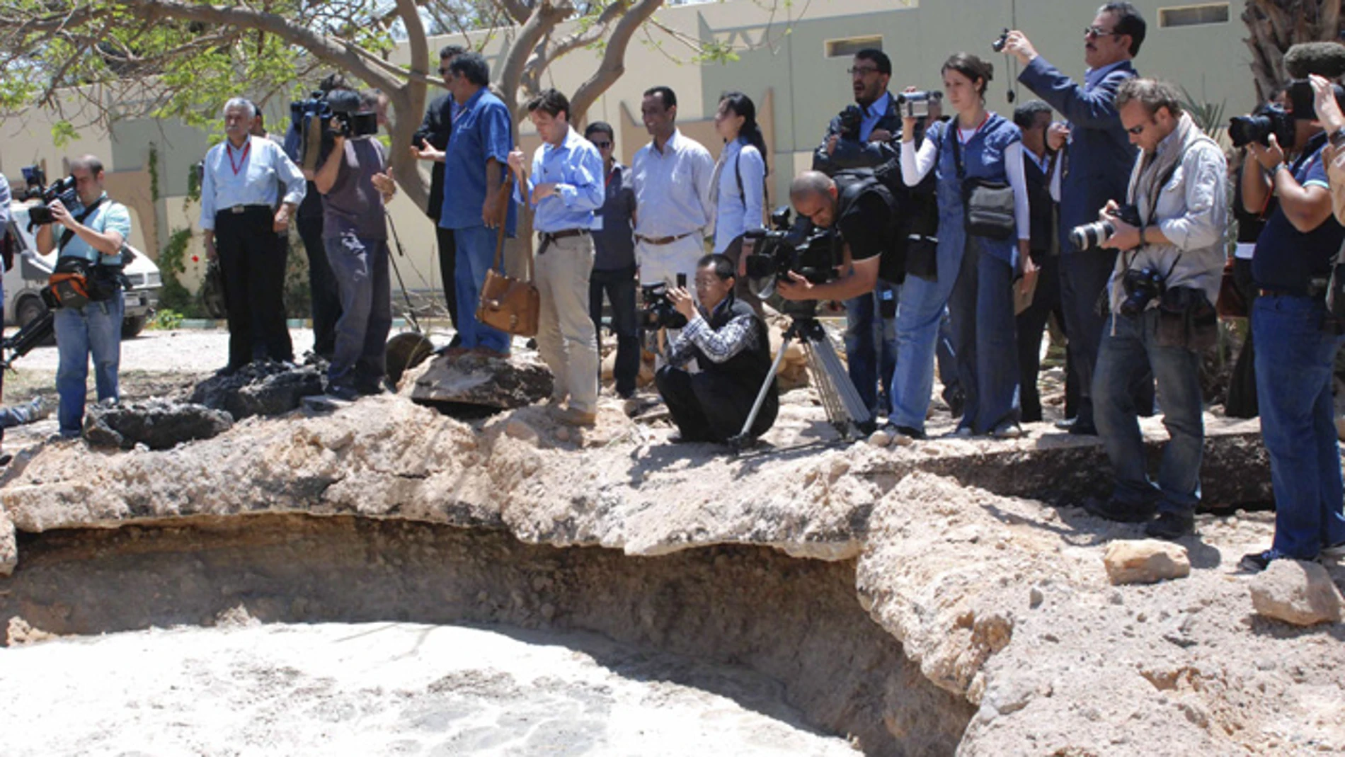 Los reporteros gráficos observan el crater causado por un bombardeo de la OTAN en Bab al-Aziziya. Los reporteros gráficos observan el crater causado por un bombardeo de la OTAN en Bab al-Aziziya.