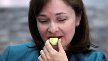 La ministra rusa de Comercio y Desarrollo, Elvira Nabiullina, come un pepino de origen ruso