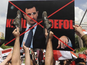 Manifestantes turcos y sirios enarbolan una pancarta en contra de Bachar al Asad. Manifestantes turcos y sirios enarbolan una pancarta en contra de Bachar al Asad.