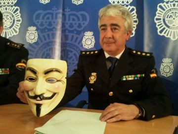 Comisario de la Brigada de Investigación Tecnológica sosteniendo una careta de Anonymous