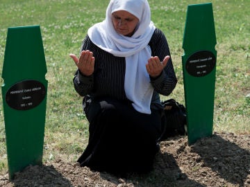 Una mujer reza ante las tumbas de sus dos hijos muertos en la matanza de Srebrenica