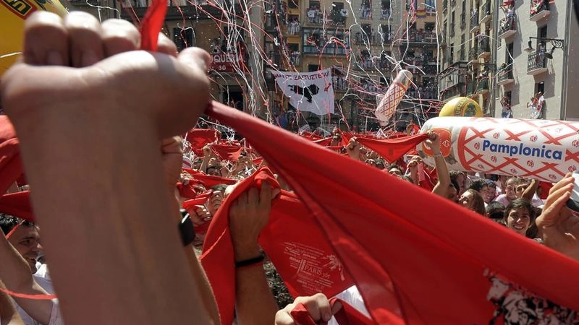 Jóvenes entusiastas alzan sus pañuelos tras el "Chupinazo"