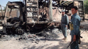Policías afganos hacen guardia junto a un camión quemado por un grupo de afganos 