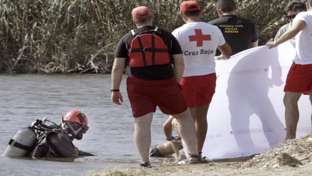 Miembros de la Cruz Roja y de la Guardia Civil sacan del agua el cuerpo sin vida de uno de uno de los niños.