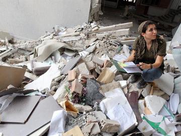 Una periodista extranjera toma notas entre los escombros de un edificio gubernamental atacado por la OTAN