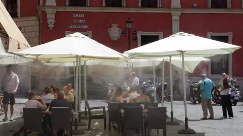 Turistas se refrescan en una terraza Turistas se refrescan en una terraza