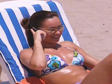 Una joven habla por el móvil en la playa.