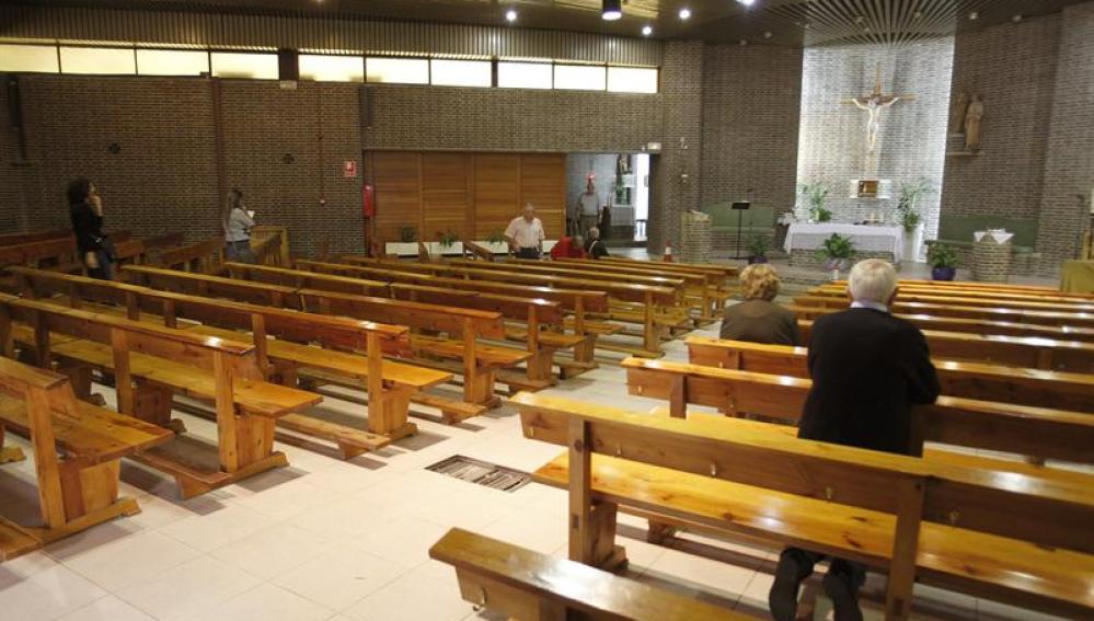 Varias personas rezan en la iglesia de Santa María del Pinar