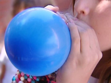 Un niño inflando un globo. Un niño inflando un globo.