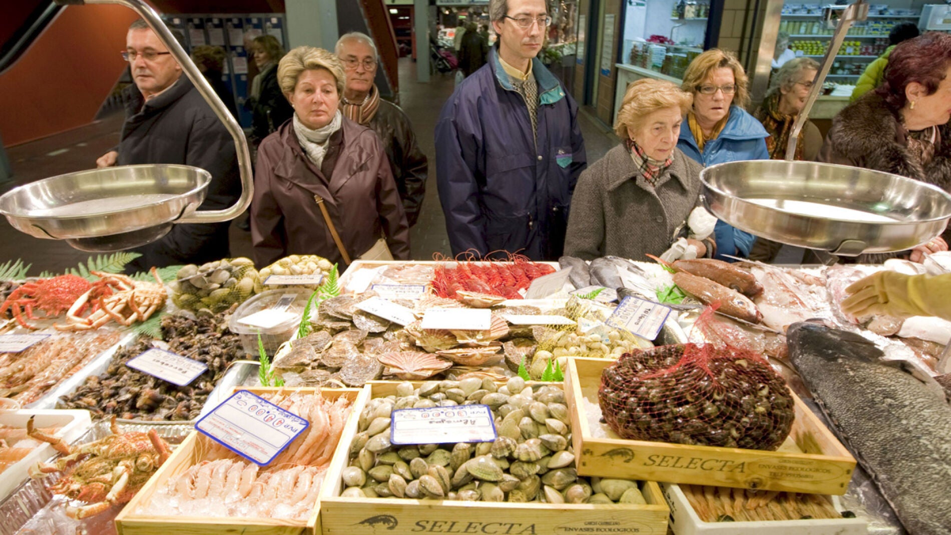 Un grupo de personas hacen cola ante una pescader&iacute;a en el Mercado de Vitoria