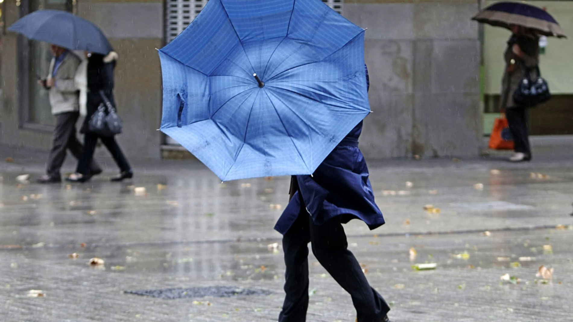 Una mujer se protege de la lluvia y el viento Una mujer se protege de la lluvia y el viento