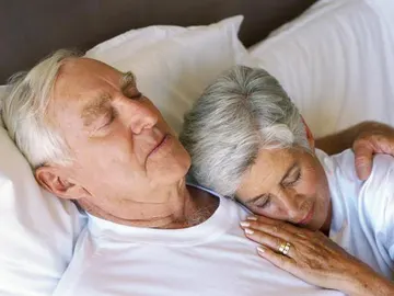 Una pareja madura descansa tumbada Una pareja madura descansa tumbada