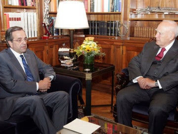 El presidente griego, Karolos Papoulias, conversa con el líder de la oposición, Antonis Samarás