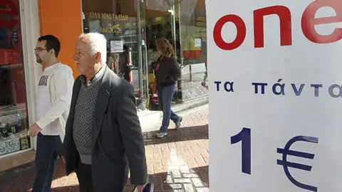Unos peatones pasan al lado de una tienda de "todo a un euro" en Atenas Unos peatones pasan al lado de una tienda de "todo a un euro" en Atenas