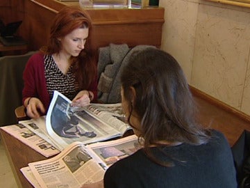 Dos jóvenes leen los diarios económicos