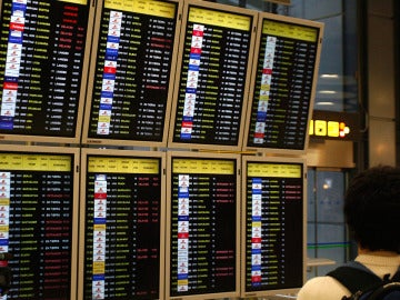 Un pasajero consulta la lista de vuelos en Barajas