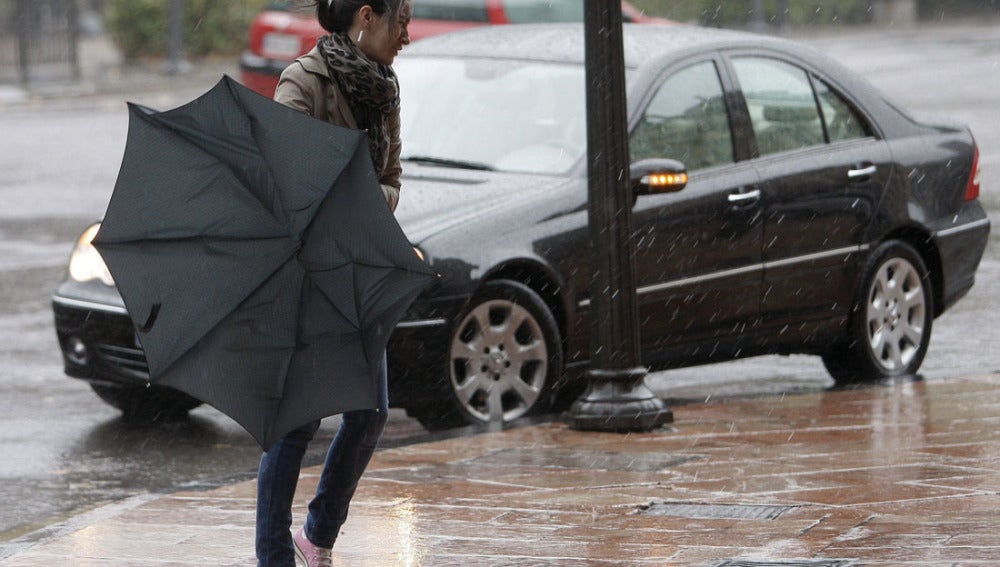 Una chica lucha contra el viento en una ciudad española