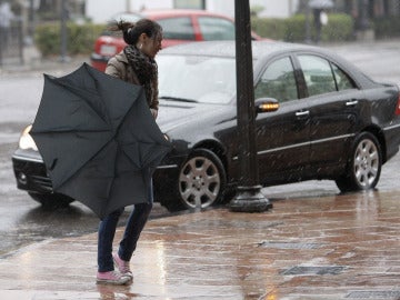 Una chica lucha contra el viento en una ciudad española