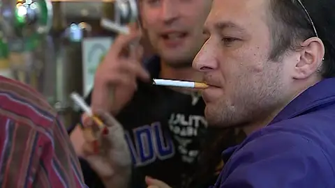 Un hombre fuma en un bar Un hombre fuma en un bar