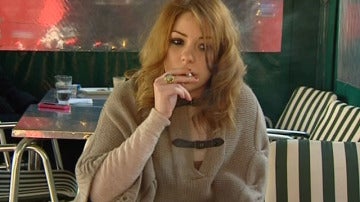 Una joven fuma en la terraza de un restaurante