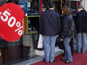 Varias personas delante de un escaparate en rebajas Varias personas delante de un escaparate en rebajas