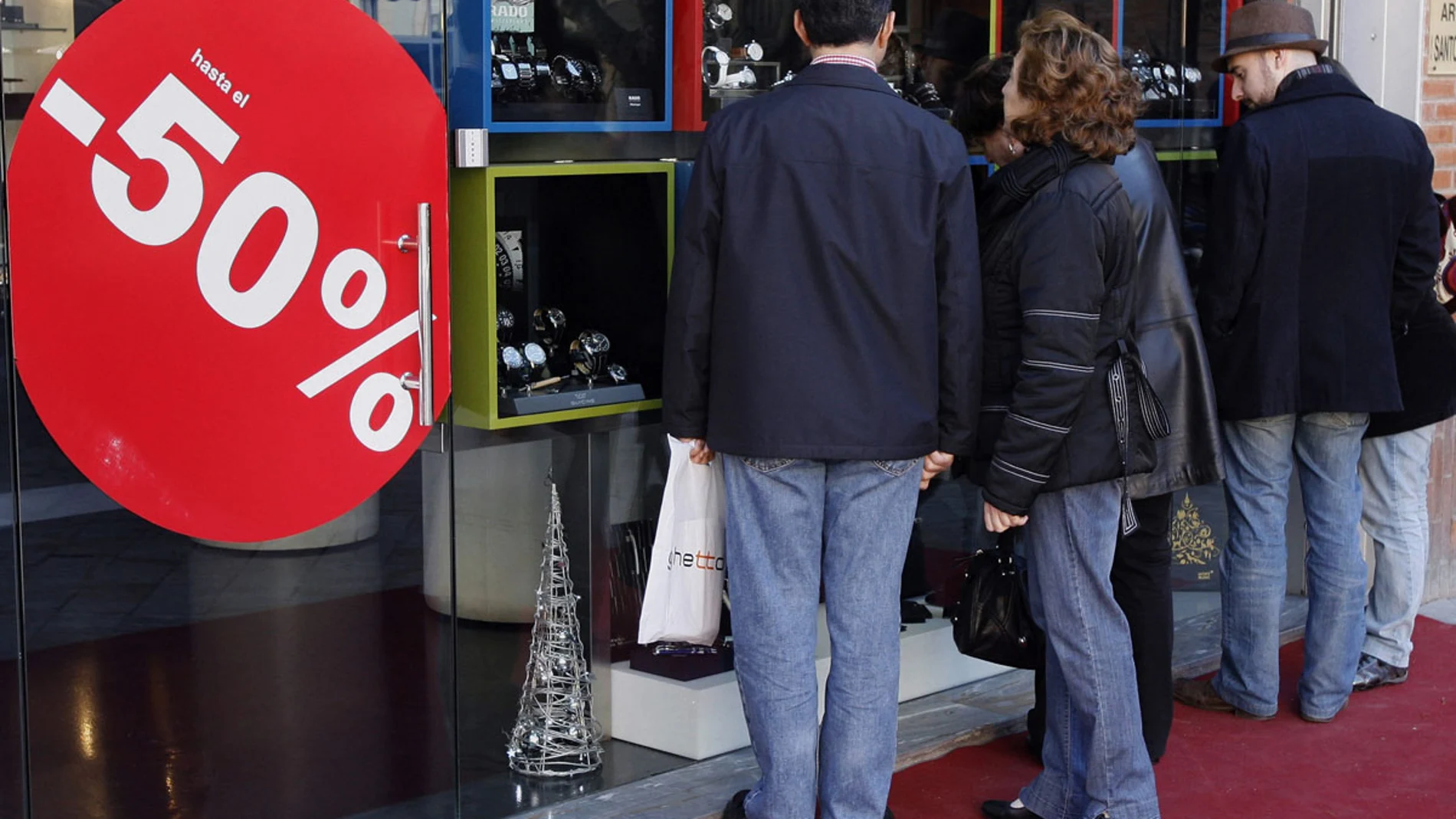 Varias personas delante de un escaparate en rebajas Varias personas delante de un escaparate en rebajas