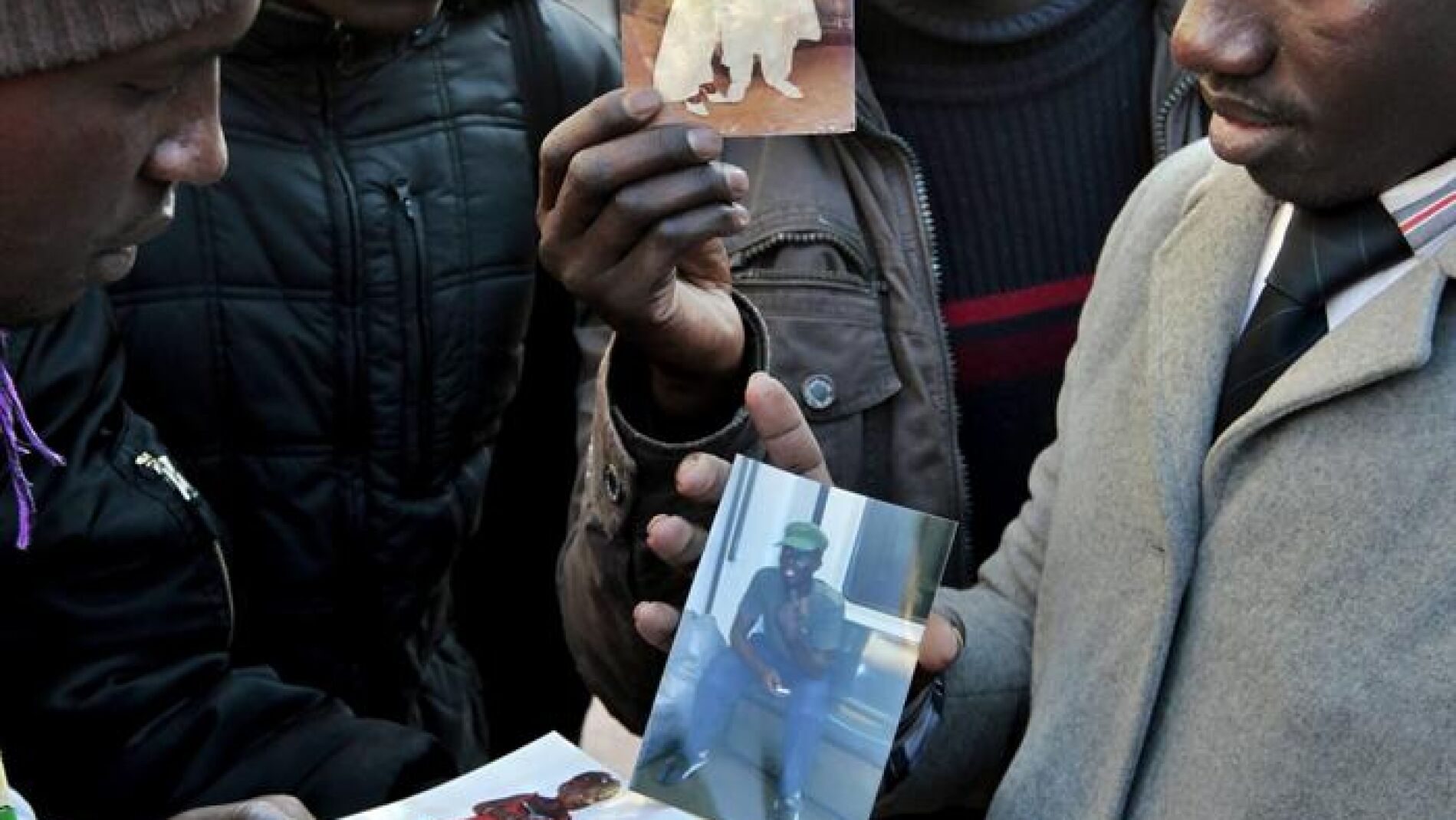 Senegaleses muestran las fotos de su compatriota asesinado en Barcelona.