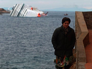 Una mujer en la isla de Giglio con el crucero Costa Concordia a su espalda