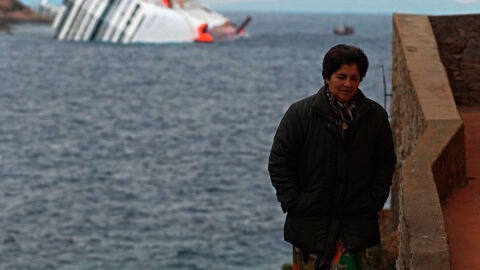 Una mujer en la isla de Giglio con el crucero Costa Concordia a su espalda