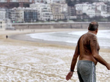 Un hombre en la playa nevada en San Sebastián Un hombre en la playa nevada en San Sebastián