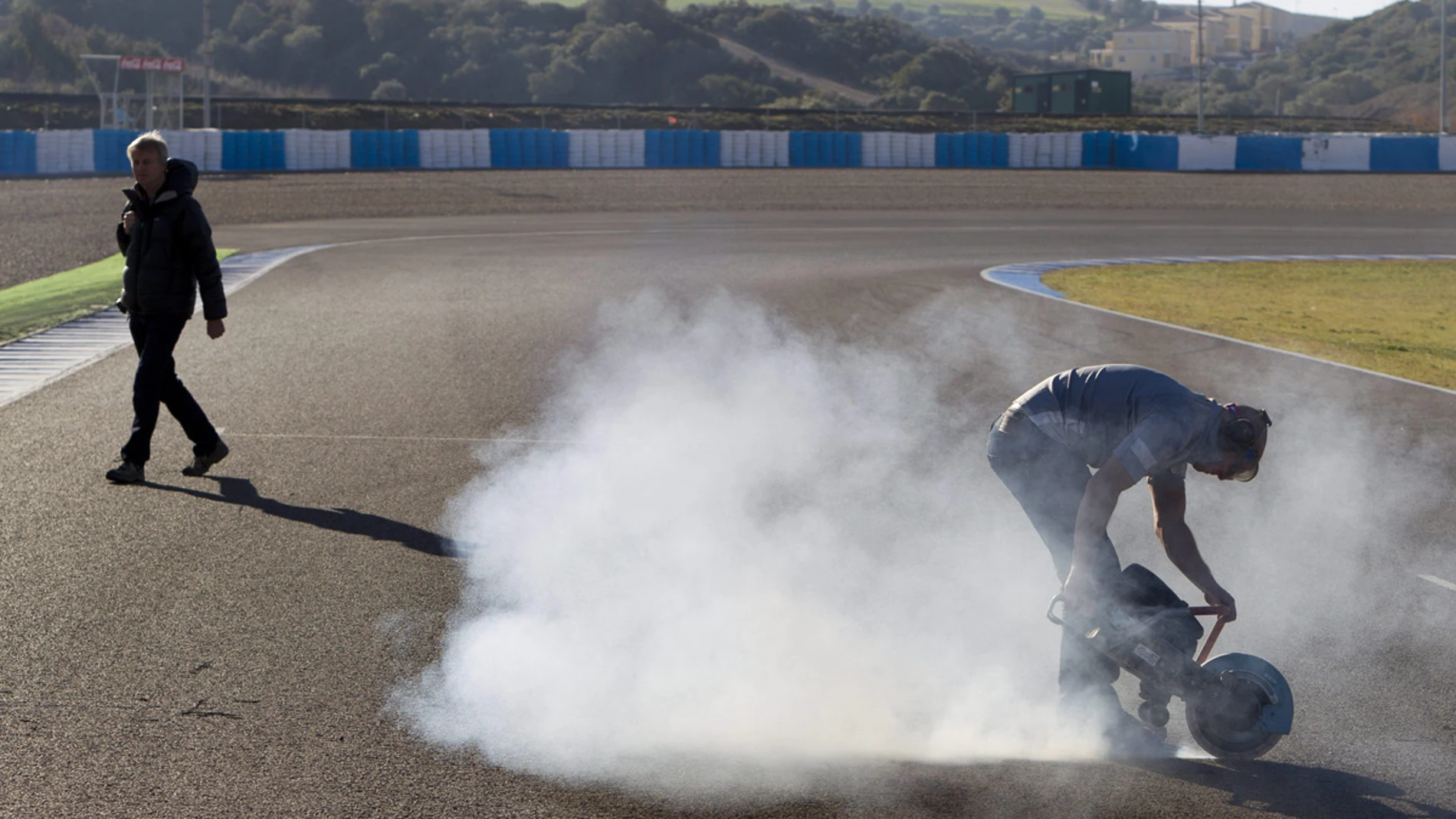 Un técnico corta el asfalto para colocar sensores en la recta de meta en el Circuito de Jerez