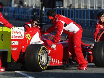 Losa mecánicos de Ferrari remolcan el F2012 al box