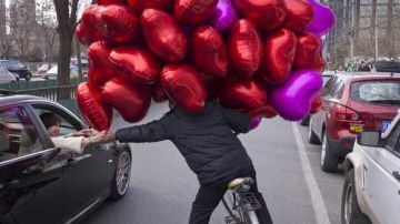 Un comerciante vende globos de corazón en Pekín