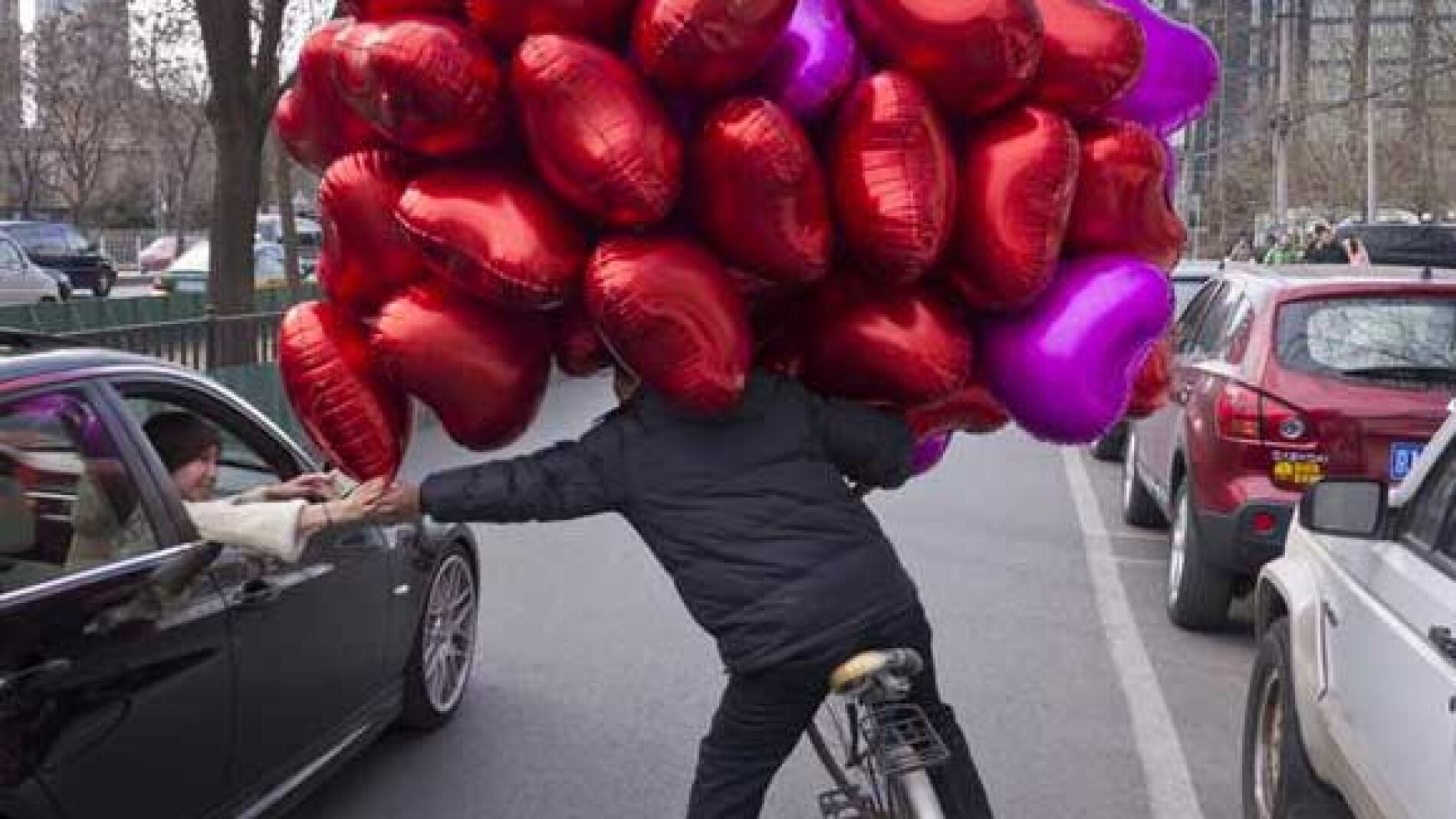 Un comerciante vende globos de coraz&oacute;n en Pek&iacute;n