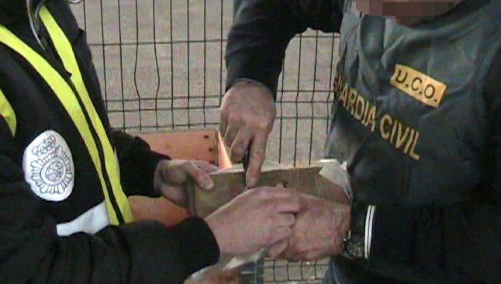 Agentes de la Guardia Civil procede a abrir uno de los fardos