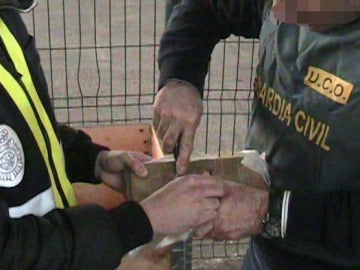 Agentes de la Guardia Civil procede a abrir uno de los fardos Agentes de la Guardia Civil procede a abrir uno de los fardos