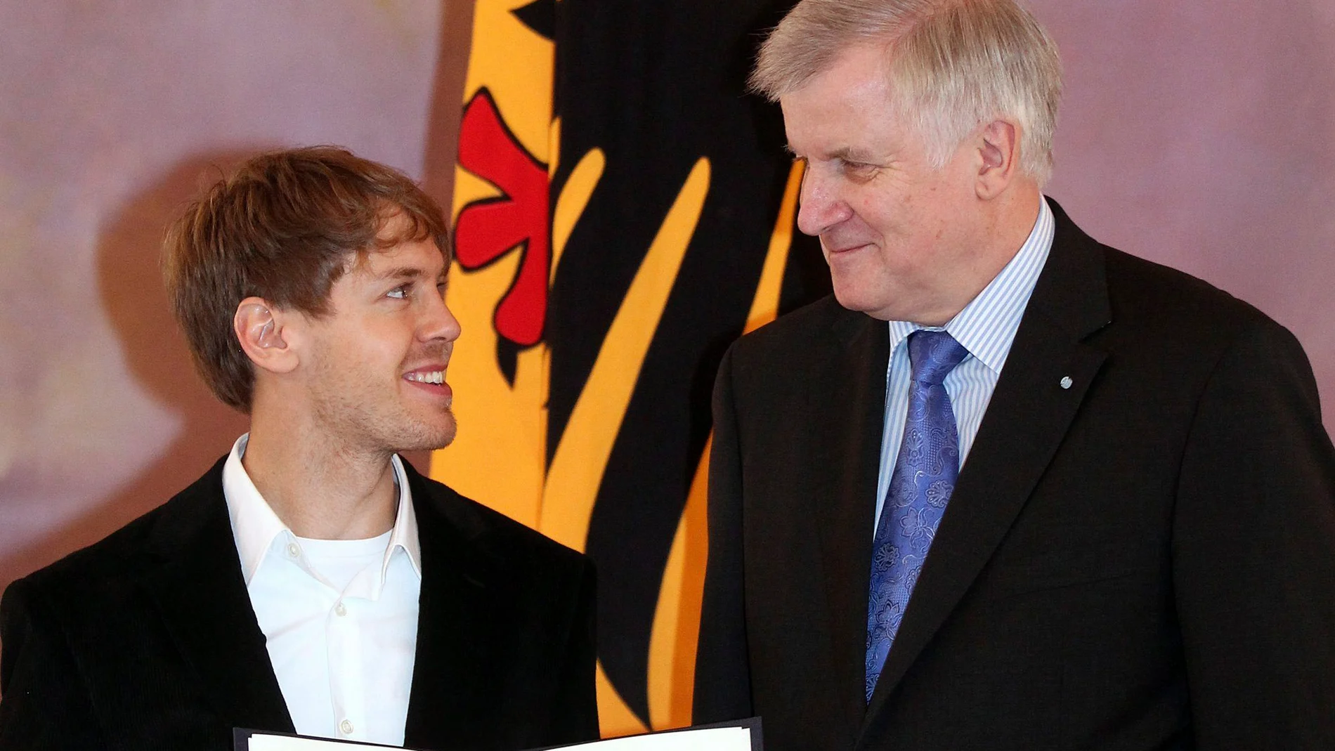 El primer ministro bávaro. Horst Seehofer, entrega la condecoración a Vettel