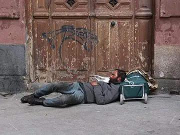 Imagen de archivo de una persona indigente que duerme en la calle. Imagen de archivo de una persona indigente que duerme en la calle.