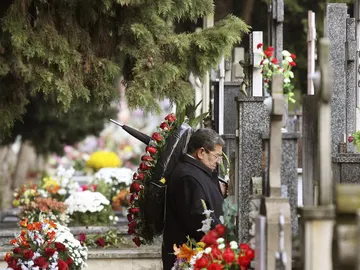Un hombre ante una tumba en un cementerio Un hombre ante una tumba en un cementerio